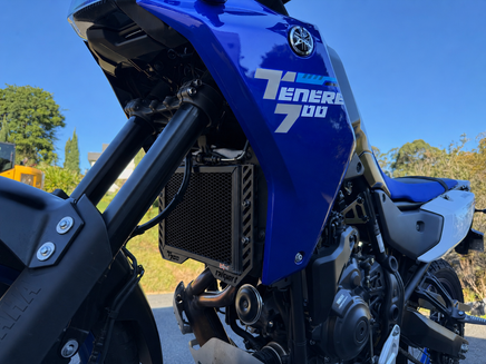Blue Yamaha Tenere 700 motorcycle with clear blue sky in the background showing off a black Rad Guard fitted giving the radiator protection