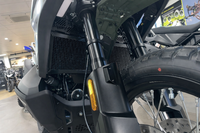 Close-up of a motorcycle's front wheel and suspension system in a showroom setting showing off Black Rad Guard fitted to a CFmoto 1000mt-x