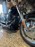 Close-up of a motorcycle wheel and suspension on a textured surface also showing the rad guard in black just blending in to the bike for a Harley Davidson Heritage Classic 117 