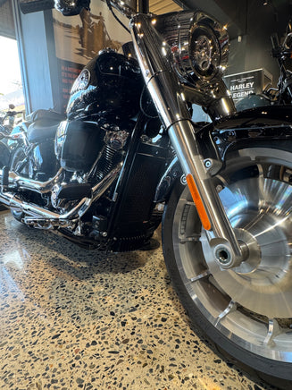 Close-up of a motorcycle wheel and suspension on a textured surface also showing the rad guard in black just blending in to the bike for a Harley Davidson Heritage Classic 117 